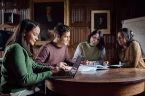 A group of students with a professor studying. 