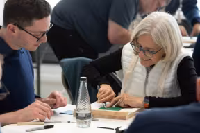 People at a table taking part in a printing workshop