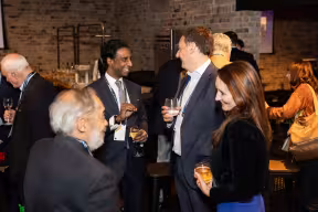 a group of Oxford alumni and supporters chatting at an event
