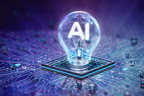 Illustration showing an illuminated lightbulb with the word ‘AI’ attached on top of a computer chip.