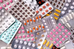 Close up of a pile of various packets of antibiotics of different colours and sizes.