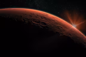 A sunrise as seen from Mars. The red surface of the planet is illuminated by the disc of the sun appearing on the horizon. The background is black outer space with stars. 