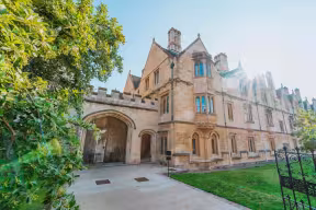 Image of low sun over the gates of Magdalen College
