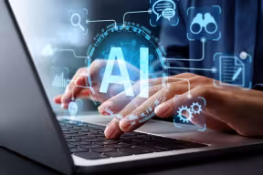 Image shows a person using a laptop with the graphic AI floating above their hands and various graphs such as chat bubbles and binoculars circling around it