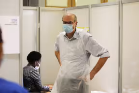 Photo | Prof. Pollard preparing to deliver coronavirus vaccinations at the Kassam Stadium (c) Oxford Health NHS Foundation Trust