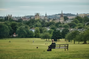 A view from Oxford from South Park, with a person sat on a bench
