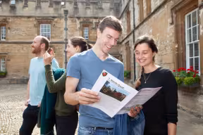 Image of visitors to Oxford Open Doors at St John's College with a guide book ready to explore