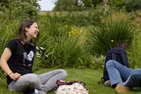 Two students sat in the grounds of the Botanic Garden