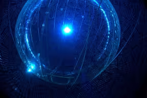 A round chamber with walls made up of photomultiplier tubes, illuminated by a central blue light.