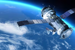 A satellite in orbit over the earth. The satellite has a cylindrical body with two arms made of solar panels.