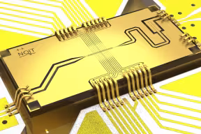 3D image of a rectangular quantum computing chip, against a circuit-board background. The chip says ‘NQIT ++’. 