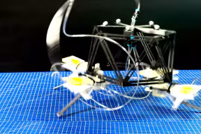 A small tabletop robot with a frame based on a pentagon shape and four legs.