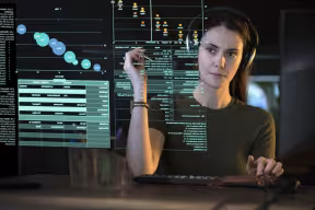 A woman studies a see-through display showing a variety of data and information.
