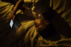 A person in bed looking at their phone. 