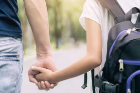 Parent holding child's hand