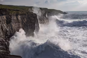 Rough ocean with waves crashing into the rocks.