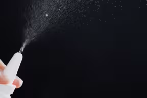 Photo | close up of a spray bottle drops on black background