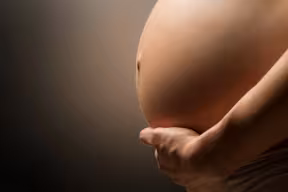 Pregnant woman holding her belly