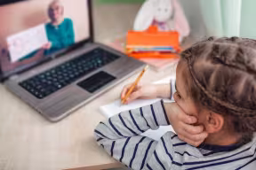 Young girl learning remotely at a lap top