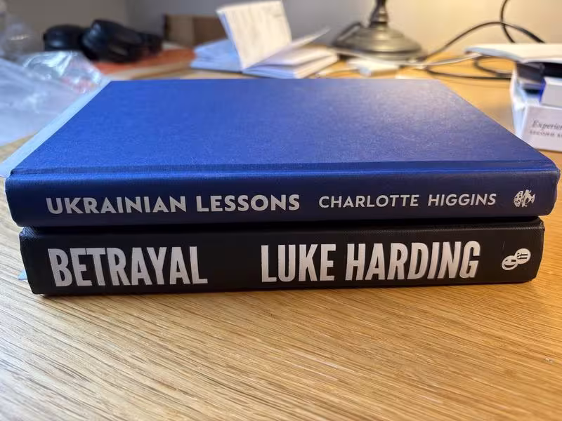 Two hardback books on their side, Betrayal by Luke Harding and Ukrainian Lessons by Charlotte Higgins